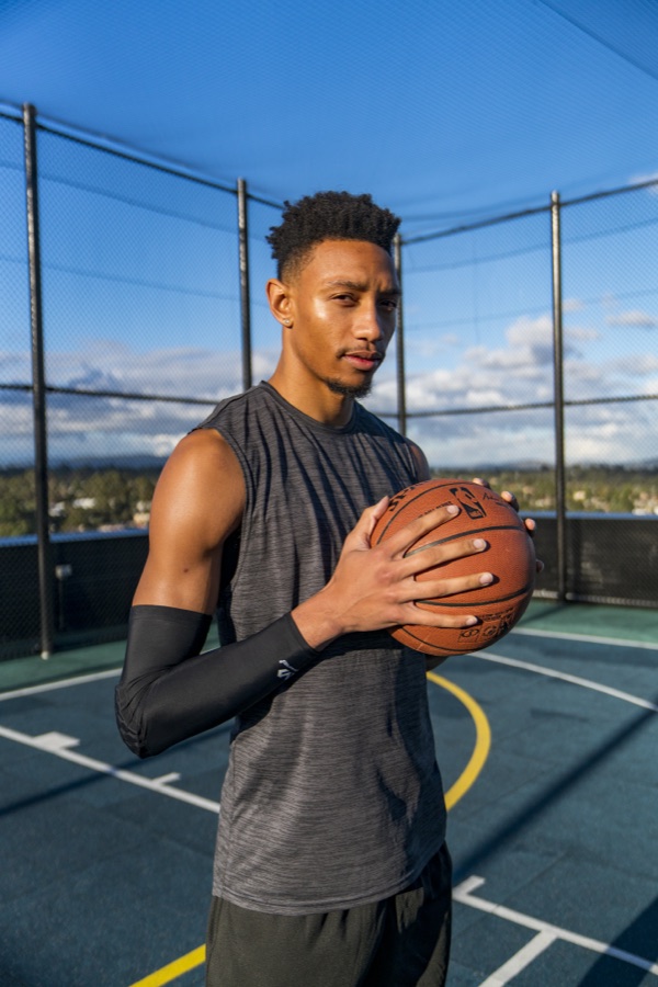 Basketball player holding a ball on an outdoor court