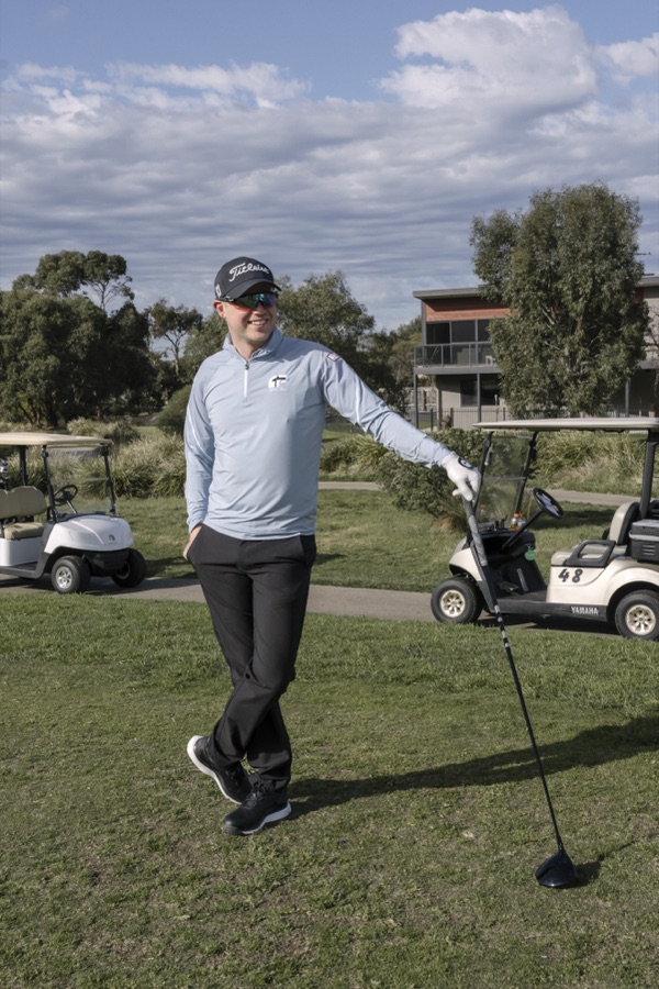 Golfer mid swing on the fairway