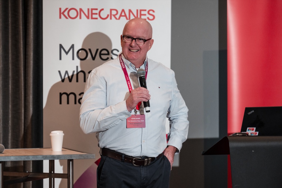 Speaker with a microphone beside the Konecranes banner