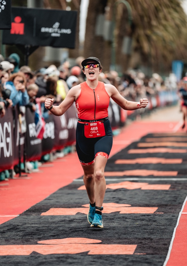Runner on the red finish carpet at a triathlon