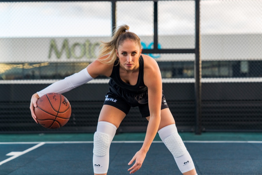 Basketball player dribbling low on an outdoor court