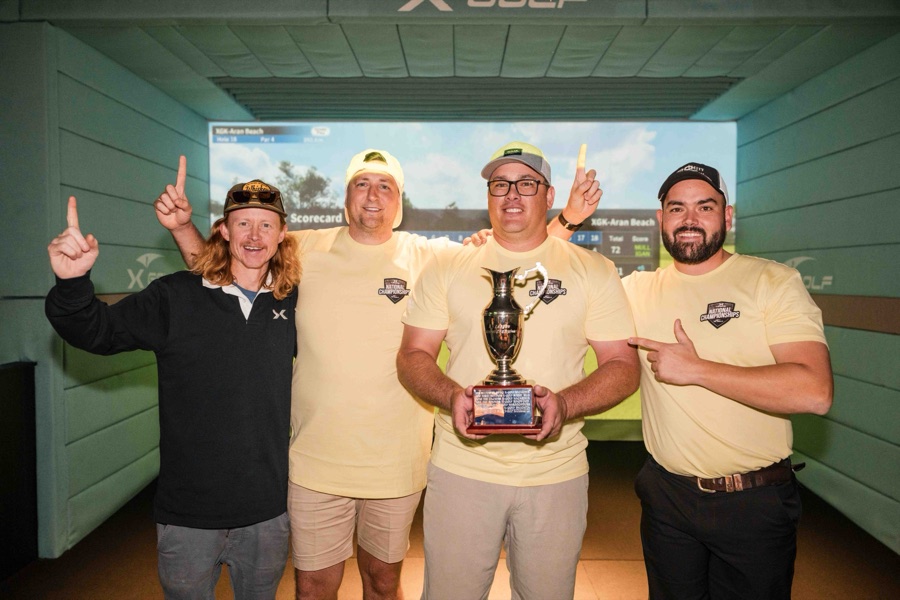 Team celebrating with the trophy in a simulator bay