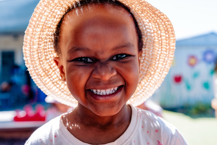 Child in a straw hat, smiling