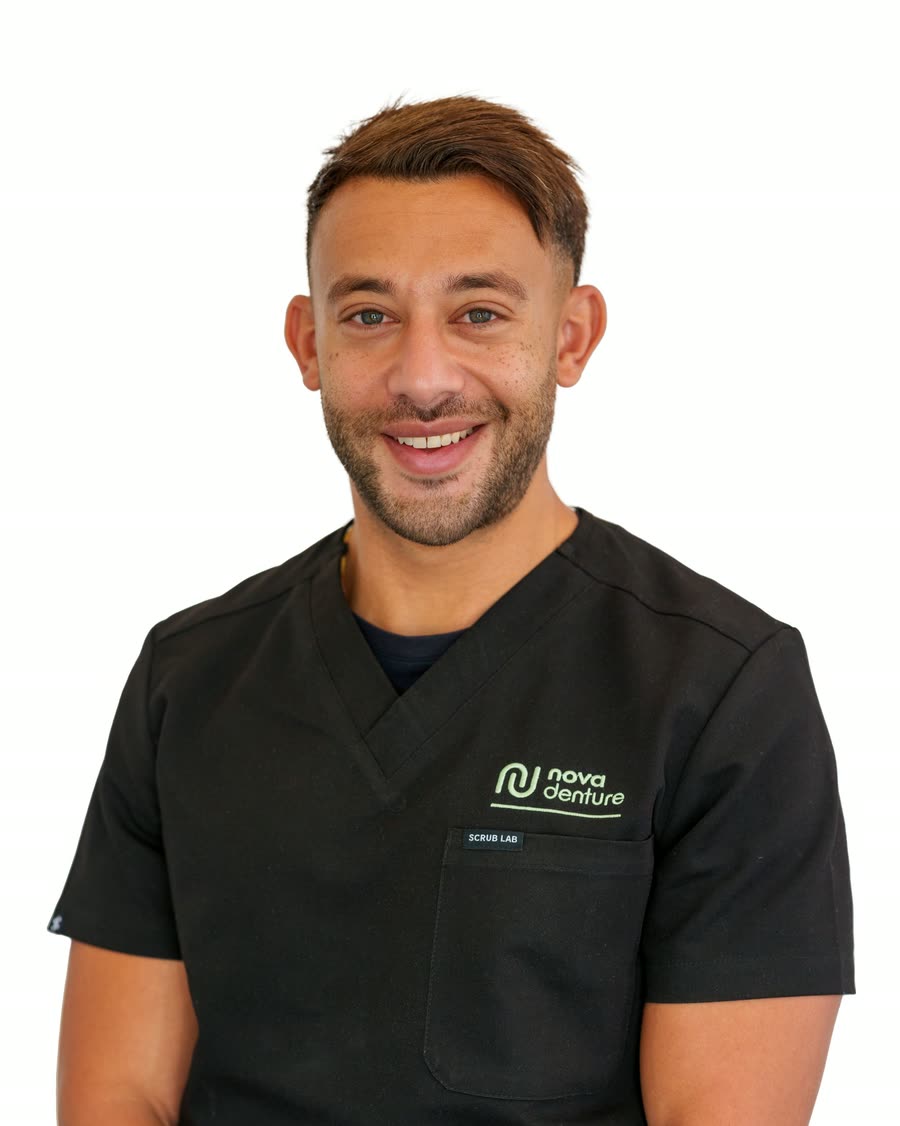 On-location headshot of a dental clinician in black branded scrubs