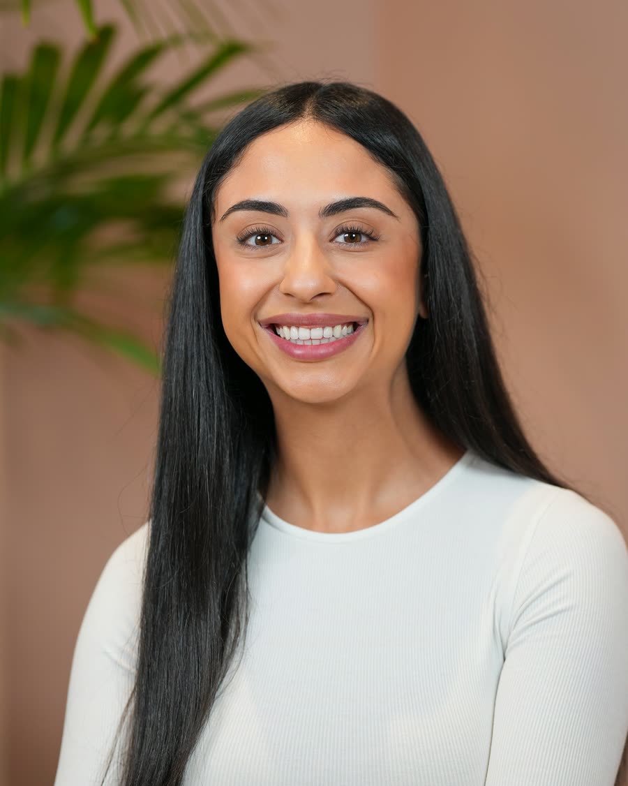 On-location headshot of a team member in white against tropical planting