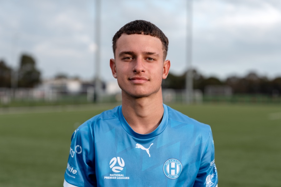 Young footballer in club kit on the pitch