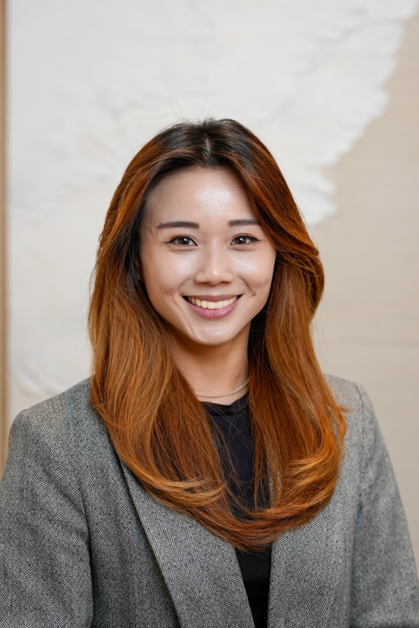 Corporate headshot of a woman in a grey blazer