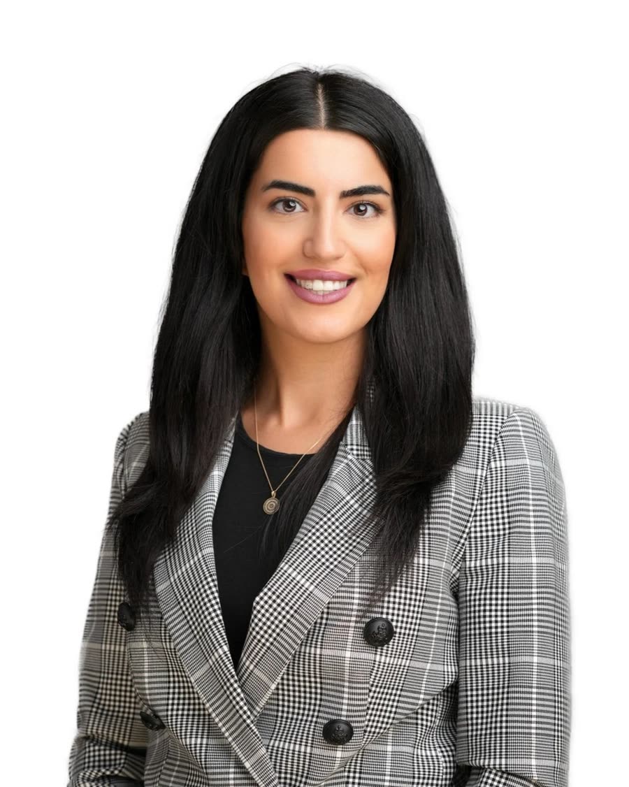 Studio headshot of a professional in a grey check blazer on a white background