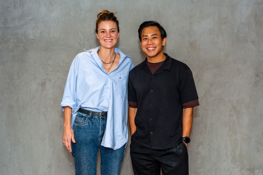 Two people photographed together against a plain wall