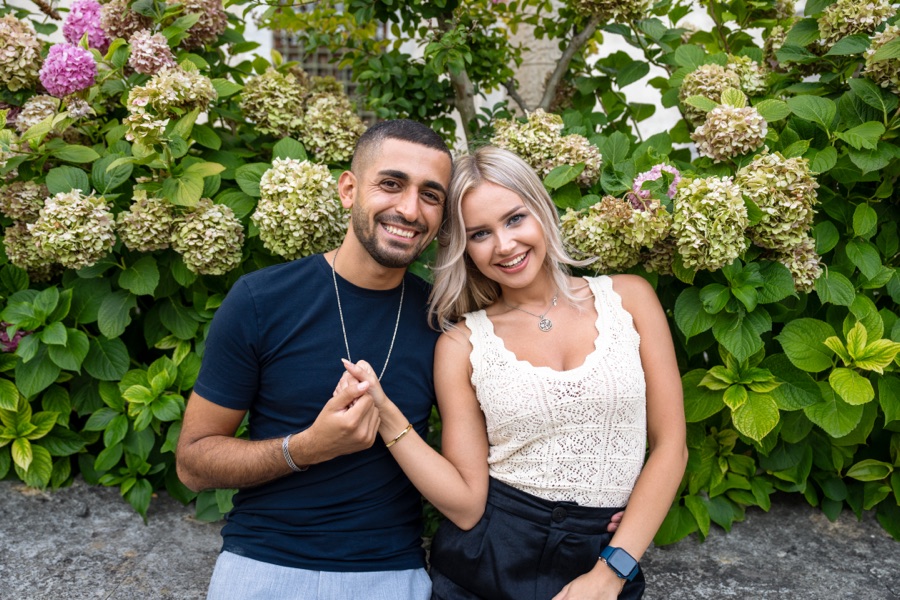 Couple photographed in front of flowering hydrangeas