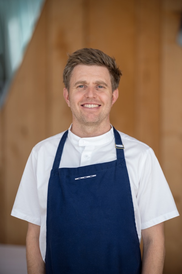 Chef in a navy apron photographed on location in his own kitchen