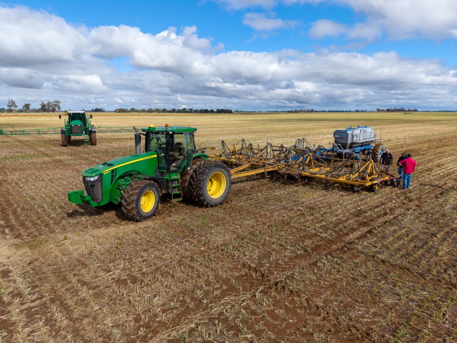 Aerial of a tractor and seeder working a harvested paddock