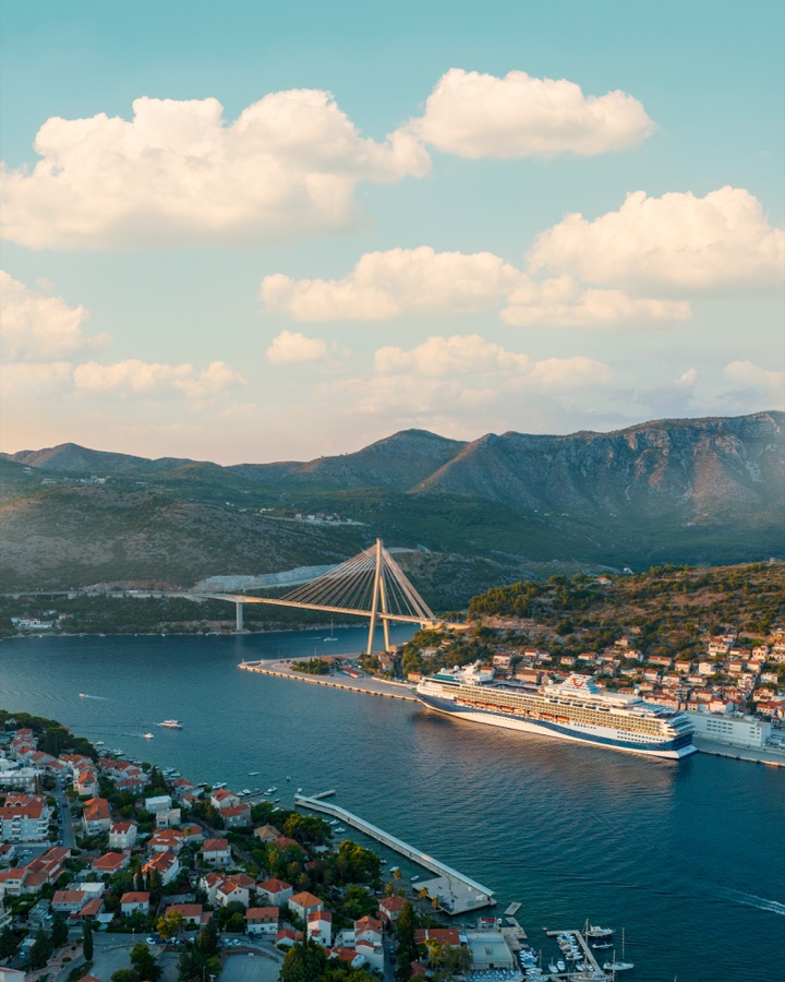 Aerial of a coastal town, its bridge and a moored ship