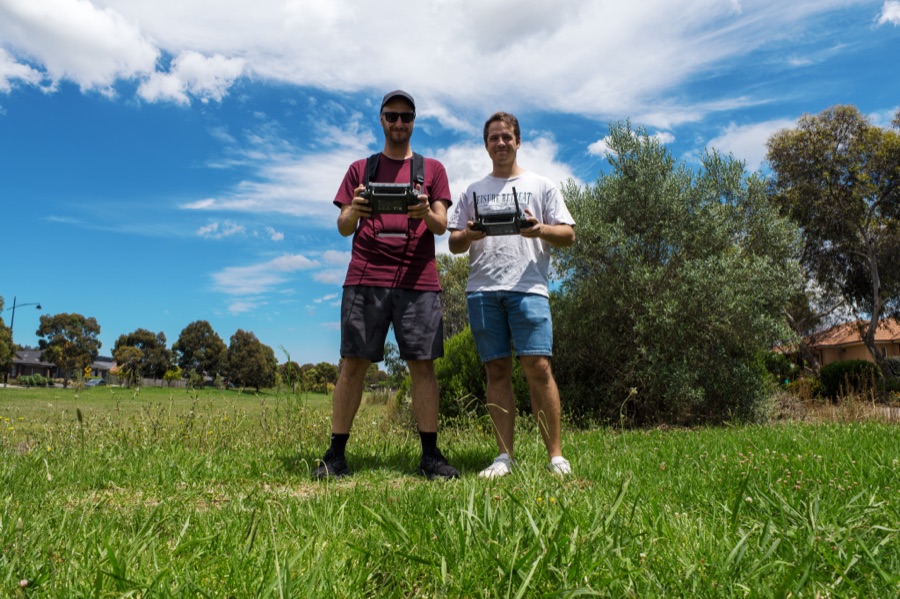 Two operators flying a survey drone over open pasture
