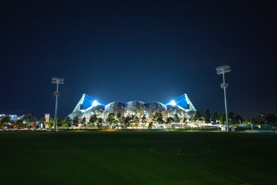Lit marquees on a field at night