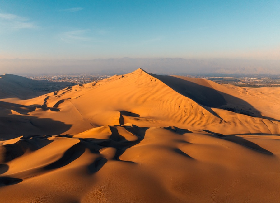 Aerial of a desert dune under low sun