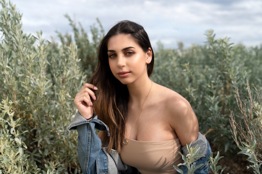 A portrait in denim shot against coastal scrub