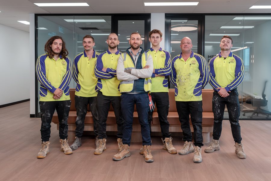 Trades team in branded workwear photographed together in a finished office