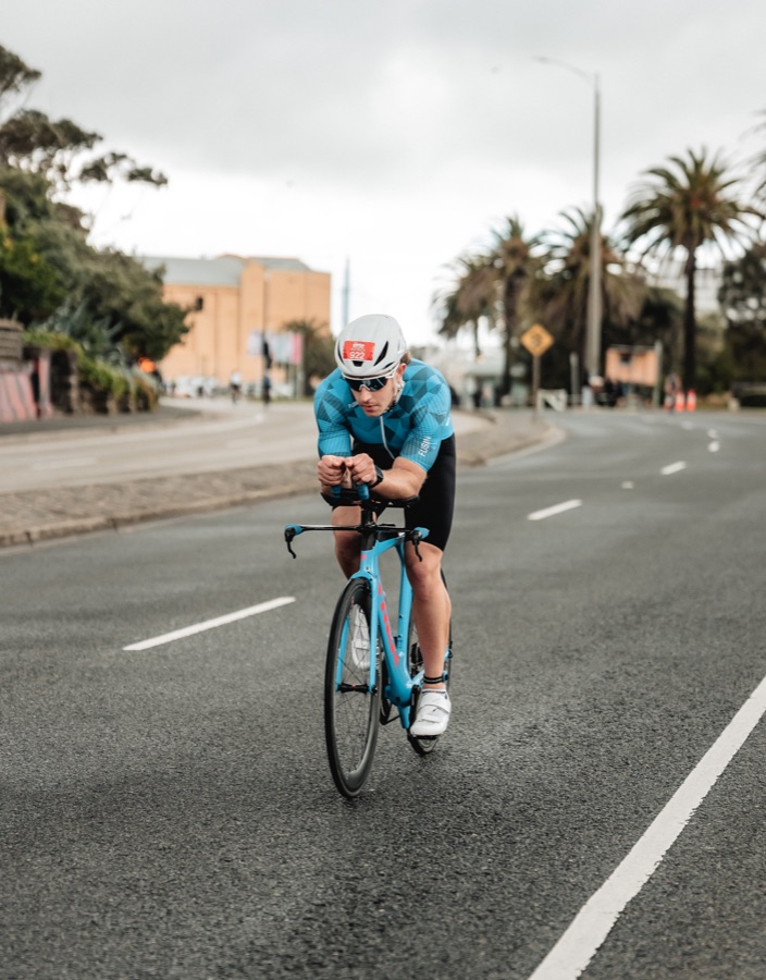 Triathlete riding in aero position on an open road