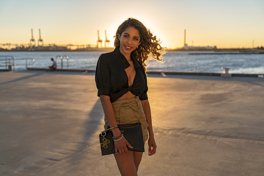 A portrait at dusk on the waterfront with the port beyond
