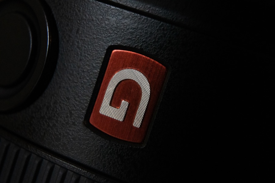 Close detail of an embossed brand badge on matte black