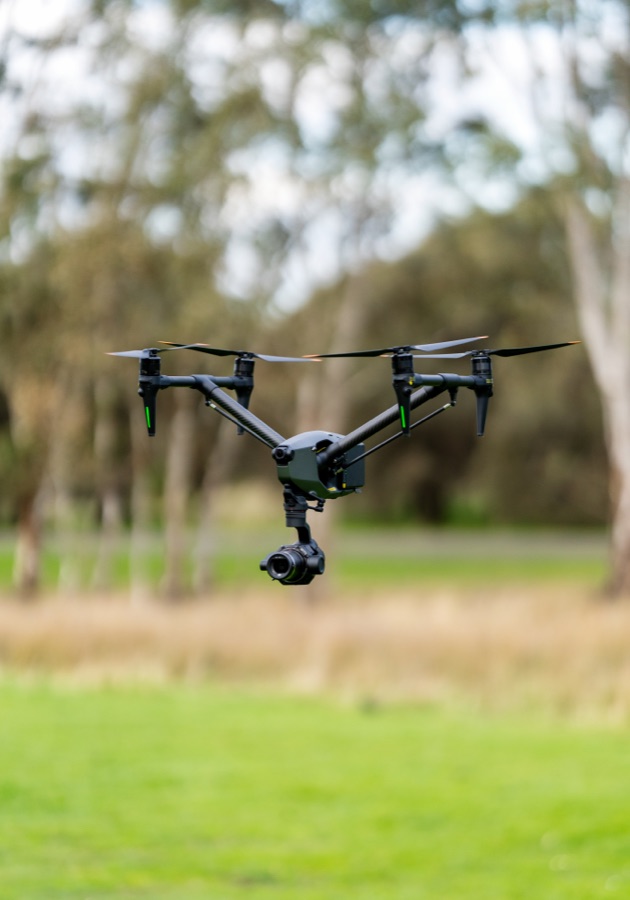 A camera drone hovering above open grass